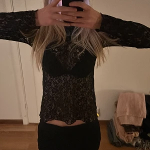 Svart spetsblus - Säljer en elegant svart spetsblus med långärmad design. Perfekt för en utekväll eller fest. Blusen har en tight passform och är tillverkad i ett vackert spetsmaterial som ger en sofistikerad look.