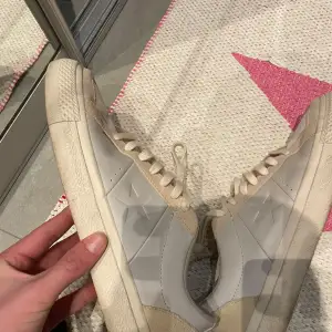 Säljer ett par snygga beige sneakers från Converse i bra skick. De har en klassisk design med stjärndetaljer på sidan och snörning framtill. Perfekta för vardagsbruk och ger en stilren look. Sulan har det ikoniska Converse-mönstret.