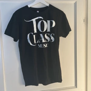 Svart t-shirt med tryck - KÖP INTE DENNA ANNONS UTAN SKRIV SÅ LÄGGER JAG UPP EN!, Säljer en svart t-shirt med texten 'Top Class Music' i vitt tryck. Perfekt för musikälskare som vill ha en stilren look. T-shirten har en normal passform och är kortärmad, vilket gör den idealisk för både vardag och fest. Materialet känns mjukt och bekvämt mot huden. Finns endast 16 exemplar kvar, OBS tidigare pris 250kr nu 100 finns i large medium och small