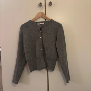 Grå kofta från Zara - Säljer en superfin grå kofta från Zara i bra skick. Den har långa ärmar och knäpps med stiliga knappar framtill. Perfekt för höst och vår när du vill ha något mysigt men ändå snyggt. Passar både till vardags och lite finare tillfällen. 🩶