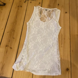Vit ärmlös topp med spetsdetaljer - Säljer en superfin vit ärmlös topp med spetsdetaljer.  Den är i storlek S/36 och säljer för 100kr🌸