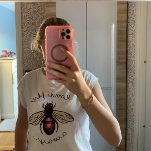 Vit t-shirt med bi-motiv från Coster Copenhagen - Säljer en söt vit t-shirt från Coster Copenhagen i storlek XS. Den har ett tryck av ett bi med texten 'come fly away'. Perfekt för en avslappnad sommarlook! 🐝