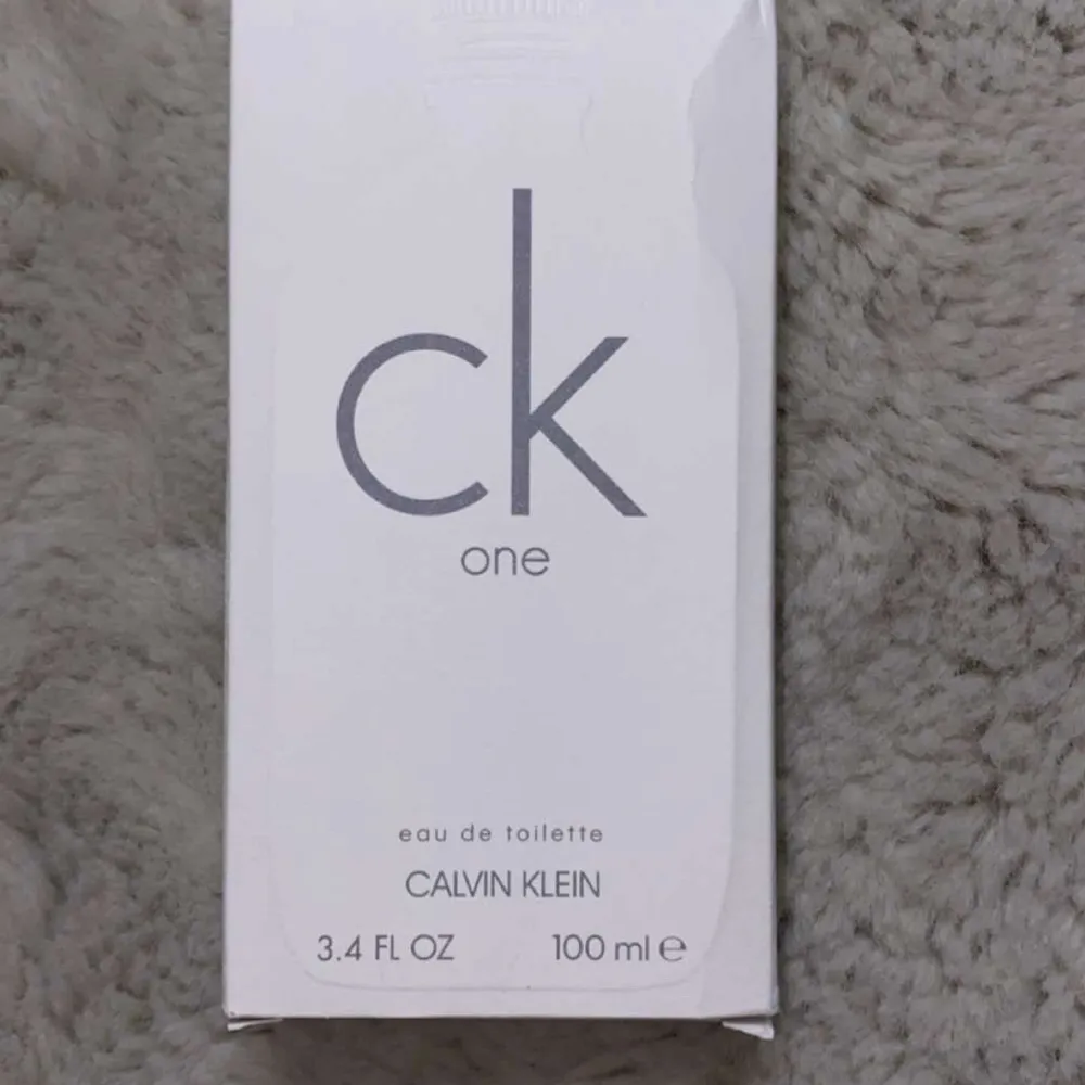 Säljer en fräsch och klassisk CK One Eau de Toilette från Calvin Klein. Flaskan är stilren och frostad med en enkel design. Perfekt för både vardag och speciella tillfällen. Innehåller 100 ml.. Parfym.