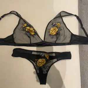 Säljer ett set med svart bh och trosa i transparent spets med vackert gult och grått blommigt broderi. Perfekt för speciella tillfällen eller när du vill känna dig extra fin. 🖤💛(PS: aldrig använd men lapparna är borttagna) Bh- 75c, trosa- S/M