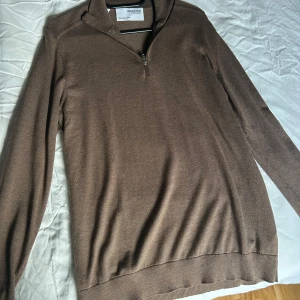 Brun tröja från Selected Homme - Säljer en stilren brun tröja från Selected Homme. Den har en dragkedja vid halsen och är perfekt för både vardag och lite finare tillfällen. Tröjan är i ett mjukt material och har långa ärmar. Passar perfekt till höst- och vårgarderoben!