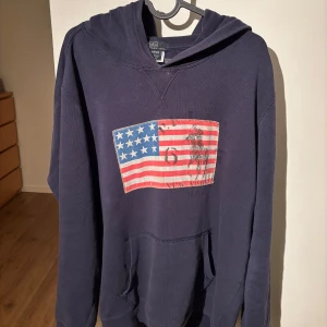 Mörkblå hoodie från Polo Ralph Lauren - Säljer en snygg mörkblå hoodie från Polo Ralph Lauren. Tröjan är använd men är fortfarande i hyfsat skick. Skriv privat ifall ni har frågor:)