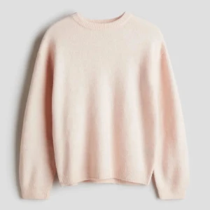 Ljusrosa stickad tröja - Supermjuk och lyxig ljusrosa kashmirtröja som är perfekt för kyliga dagar. Den har en klassisk rund hals och långa ärmar, vilket gör den både stilren och bekväm. Passar perfekt till både vardag och fest. Ett måste i garderoben! 💖