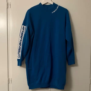 Blå oversized hoodie  - Säljer en cool blå oversized hoodie från New yorker. Den har långa ärmar med vit text längs sidorna. Perfekt för en avslappnad stil och passar bra till både jeans och joggers. Superbekväm och normal i storlek! 