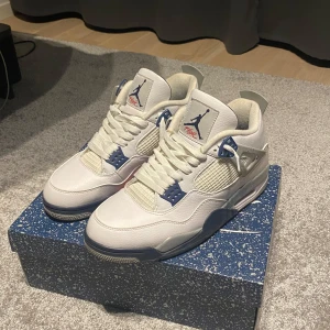 Air Jordan 4 Retro White/Midnight Navy - Säljer ett par Air Jordan 4 Retro i färgen White/Midnight Navy. Skorna är i nytt skick och har en snygg vit och marinblå design med röda detaljer på sulan. Perfekta för både vardag och fest! Kommer i originalkartong.