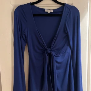 Design by si tröja - Säljer en superfin blå klänning från Design By Si. Den har en djup v-ringning och ett snyggt knyt framtill. Perfekt för både vardag och fest💙Inga fläckar eller hål storlek xs-s
