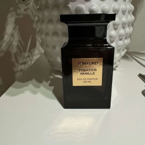 Tom Ford Tobacco Vanille Eau de Parfum - Säljer en lyxig flaska Tom Ford Tobacco Vanille Eau de Parfum, 100 ml. Flaskan är elegant och svart med en stilren design. Perfekt för den som älskar varma och kryddiga dofter med inslag av tobak och vanilj. Passar både till vardags och fest!