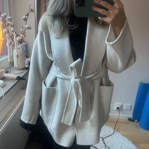 Beige kappa med knytband - Säljer denna kappa i ullmix! Den här köpt detta året och är bara använd 1 gång då jag inte gilla hur den satt på mig! Nypris vart runt 1800kr. Läs min bio för svar på eventuella frågor 