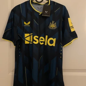 Newcastle  - Helt ny med lappen kvar. Fotbollströja från Newcastle United med namnet Isak och nummer 14 på ryggen.