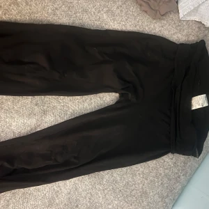 Svarta mjukisbyxor - Säljer ett par svarta yogapants i bra skick. De är superbekväma och perfekta för en chill dag hemma eller en snabb tur till affären. Byxorna har en loose passform och är gjorda av mjukt material som känns skönt mot huden. Från gina