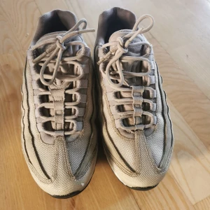 Beige Nike Air Max sneakers - Säljer ett par beige Nike Air Max sneakers i bra skick. De har en klassisk design med synlig luftdämpning i sulan och snörning framtill. Perfekta för både vardag och träning. Lite slitna men fortfarande snygga och bekväma.