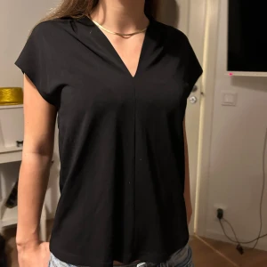 Vardagstopp - Snygg svart v-ringad topp i ett mjukt och bekvämt material från H&M. Perfekt för både vardag och fest. 