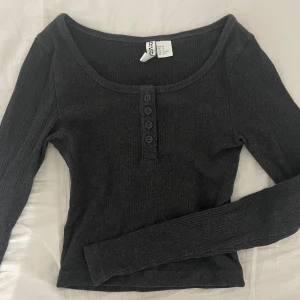Henley topp - Säljer en snygg mörkgrå/svart ribbad topp från Divided i storlek XS💞