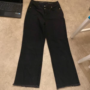 Svarta jeans från Never Denim - Säljer ett par svarta jeans från Never Denim i storlek 29/32. De har en regular wide passform och är högmidjade. Jeansen är i bra skick och har en snygg, rå kant vid bensluten. Perfekta för både vardag och fest!