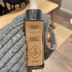 True Match Nude Plumping Tinted Serum 4-5 medium - Säljer en flaska av L'Oréal Paris True Match Nude Plumping Tinted Serum i nyansen 4-5 Medium. Den innehåller 1% ren hyaluronsyra för en återfuktande och utjämnande effekt. Perfekt för en naturlig look med lätt täckning. Säljs då jag köpte fel nyans. Öppnad men inte använd.