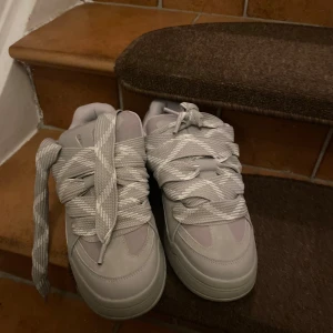 Grå sneakers från Bershka - Snygga grå sneakers från Bershka i mycket bra skick. De har en chunky design med breda snören och en bekväm sula. Perfekta för både vardag och festliga tillfällen. 