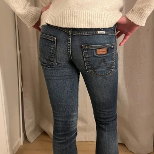 Blå jeans från Wrangler - Säljer ett par snygga blå jeans från Wrangler i mycket bra skick. De är tighta och har en klassisk femficksdesign med märkets logga på fickan. Enkla att styla och perfekta till allt! 