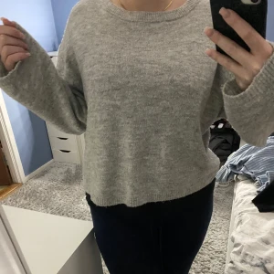 Grå stickad tröja - Mysig grå stickad tröja perfekt för kyliga dagar. Den har en avslappnad passform och långa ärmar, vilket gör den superbekväm. Perfekt att matcha med jeans för en casual look. 🧶