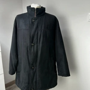 Svart kappa från Bugatti - Säljer en stilren svart kappa från Bugatti i mycket bra skick. Den har en quiltad insida med ett snyggt mönster och stängs med knappar. Perfekt för höst och vinter, och ger en elegant look. Passar både till vardags och fest. 🖤