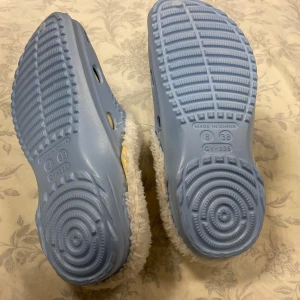 Blå tofflor med vit pälsfoder - Supermysiga blå tofflor med vit pälsfoder, perfekta för att hålla fötterna varma. De har en mjuk och fluffig insida och en stabil sula. Perfekta för kalla dagar hemma!                     Stlk kvar 36.37 , 38 och 39                            Tjocka fleece inuti  , rekommenderar att välja 2 Stlk större än som är i vanlig storlek , till exempel storlek 39 passar som är Stlk 37 i vanligt storlek 