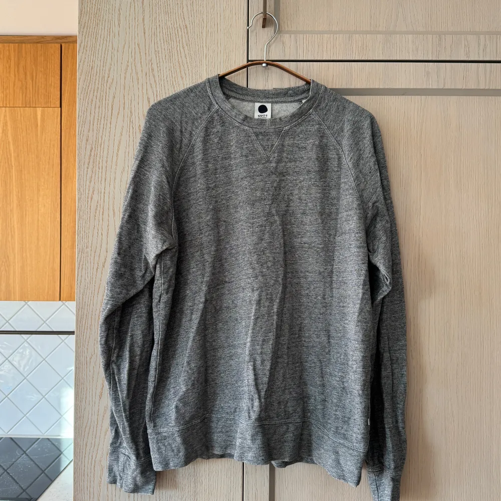 Säljer en stilren grå sweatshirt från NN07 i 100% bomull. Tröjan har en klassisk design med rund hals och långa ärmar, perfekt för både vardag och avslappnade tillfällen. Den är i mycket bra skick och passar perfekt till höst- och vårgarderoben.. Tröjor & Koftor.