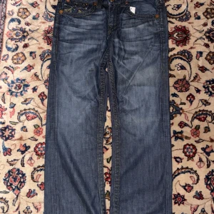 True religion jeans - Tvärfeta true religion jeans i modellen rainbow Ricky köpta i USA🇺🇸🦅🔥 galet najs färg och dunder passform👑🦅 knapp saknad på ena fickan och litet hål men annars bra skick🔥💯 dm för frågor eller funderingar👑💯