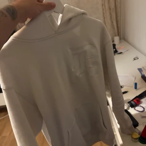 Vit hoodie - Säljer en stilren vit hoodie i mycket bra skick. Den är perfekt för både vardag och chill. Hoodien har en klassisk design med en stor ficka fram och en bekväm huva. Passar perfekt till jeans eller mjukisbyxor. Perfekt för höst och vår!