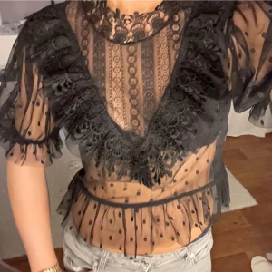 Fest topp volanger - Säljer en superfin svart spetsblus med volanger. Bra skick!