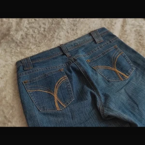 Blå jeans med broderade bakfickor - Säljer ett par snygga blå jeans i bra skick. De har broderade detaljer på bakfickorna. De är low waist jeans från authentic denim. Säljer då jag har andra byxor som används mer än dessa ❤️