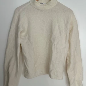 Vit stickad Alpaca tröja från NA-KD - Säljer en supermysig krämvit stickad Alpaca tröja från NA-KD i storlek S. Tröjan har en klassisk design med långa ärmar och en hög krage med lagom vida ärmar. 