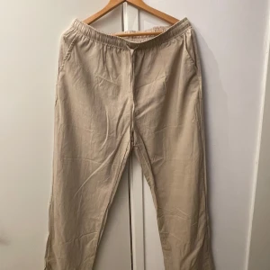Beige mjukisbyxor - Säljer ett par bekväma beige mjukisbyxor i bra skick. De har en elastisk midja med snörning för extra komfort och två sidofickor. Perfekta för en avslappnad dag hemma eller en snabb tur till affären. Passar till alla säsonger och är ett måste i garderoben!