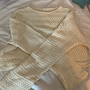 Beige stickad tröja från Pull&Bear - Säljer en superfin beige stickad tröja från Pull&Bear. Den har ett snyggt hålmönster och är perfekt för lager-på-lager under hösten. Tröjan är långärmad och har en rund halsringning. Perfekt för en mysig dag ute eller hemma! 🍂