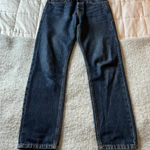 Mörkblå jeansbyxor - Säljer ett par klassiska mörkblå jeansbyxor i mycket bra skick. De har en straight passform och är perfekta för både vardag och fest. Byxorna har en midwaist och är tillverkade i slitstarkt denim. Perfekta för höst och vår!