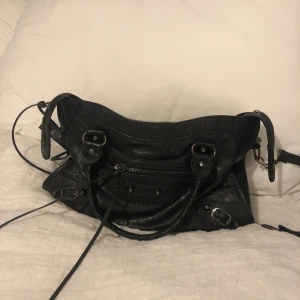 Svart väska i skinnimitation - Intressekoll på min sååå fina väska som funkar bra till både skolan och stan. Välanvänd men väl omhändertagen så inga defekter! Långt band och spegel medföljer., skriv privat för fler bilder 💗💗💗💗