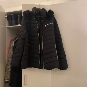 Jacka - Snygg jacka med pälsimitation på luvan.