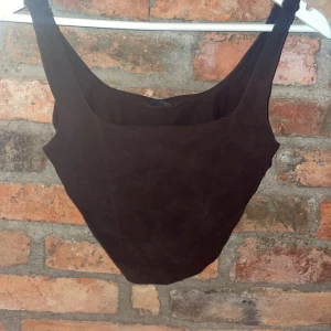 Brun linnetopp från Gina Tricot - Snygg brun linnetopp från Gina Tricot i storlek M. Perfekt för sommardagar eller som ett basplagg i garderoben. Toppen har en enkel och stilren design med breda axelband.