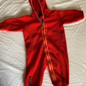 Fleeceoverall- baby - Fin Fleeceoverall i fin röd/oreange färg. Välbevarad.