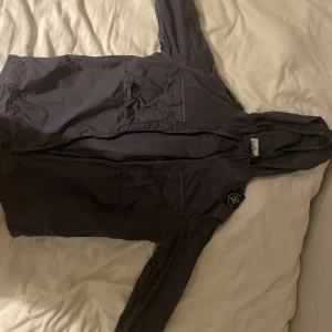 Stone island jacka - Säljer nu min stone island jacka. Jackan har en väldigt snygg grå färg och dessutom sitter badgen på axeln vilket gör den väldigt unik. Jackan är självklart äkta men kvitto saknas tyvärr då jag fått den i present. Skicket är 9/10, inte använd  mycket