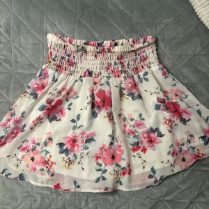 Blommig kortkjol med resårmidja - Superfin blommig kortkjol med resårmidja som ger en bekväm passform. 