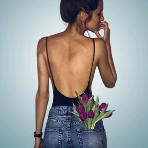 Svart body - Snygg och stilren svart body i nyskick. Den har en klassisk design med djup rygg och smala axelband för en bekväm passform. Materialet är mjukt och stretchigt, vilket ger en skön känsla mot huden. Ett måste i garderoben. Perfekt till ett par blåa jeans.