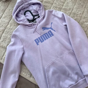 Lila Puma hoodie  - Lila huvtröja med Pumas logga på bröstet. Mycket bra skick. Använd fåtal tillfällen. Storlek M och normal passform.
