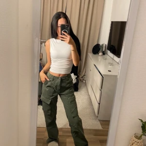 Gröna cargopants - Snygga gröna cargopants med flera fickor och en loose passform. Perfekta för en avslappnad stil. Byxorna har en högmidjad design och är tillverkade i ett slitstarkt material.