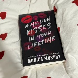 A Million Kisses in Your Lifetime - Säljer boken 'A Million Kisses in Your Lifetime' av Monica Murphy. Omslaget är svart med röda och rosa läppavtryck och vit text. Perfekt för dig som älskar romantiska berättelser. 📚💋