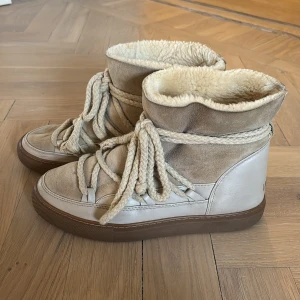 Beige boots från Inuikii - Säljer ett par snygga beige boots från Inuikii med snörning och mjukt foder. Skorna har en kombination av skinn och mocka vilket ger en stilren look. Perfekta för kyligare dagar med sin varma insida. Storlek 38.