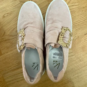  bekväma  mockaskor med gulddetaljer till alla dagar ! - Skorna är mjuka och bekväma att gå i   De är  rosa nyans, dekorerade med eleganta gulddetaljer.   Perfekta skor att använda alla dagar – både till vardag och när du vill känna dig lite extra chic.   I utmärkt skick!