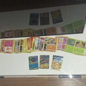 Pokémonkort samling 50+ kort - Stor samling av Pokémonkort med flera holografiska kort, inklusive Blastoise och Pikachu V. Perfekt för samlare eller spelentusiaster. Kort i olika färger och typer, med både vanliga och sällsynta kort.